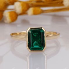 an emerald ring sitting on top of a table