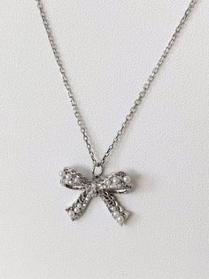 This necklace is made of a beautifully detailed ribbon pendant with tiny little pearls decors, on a delicate stainless steel chain (~1.5mm). The silver plated bow ribbon measures ~20x17mm; its filigree and vintage style is the highlight of the necklace, suitable for day-in and day out.  Materials: Ribbon charm:  Silver plated with faux tiny pearls Cable chain: Stainless steel 📿Necklace is 16 inch (40cm) in length and complimentary with an extender (~5cm) to adjust the length. 💌 A complimentary Silver Ribbon Necklace For Gift, Pearl Necklaces With Bow For Wedding, Silver Jewelry With Decorative Bow As Gift, Delicate Ribbon Necklace Gift, Silver Jewelry With Decorative Bow For Wedding, Delicate Ribbon Necklace For Gifts, Delicate Ribbon Necklace For Gift, Elegant Jewelry With Ribbon For Wedding, Silver Wedding Jewelry With Decorative Bow