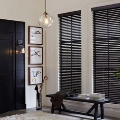 a living room with black shutters and white walls