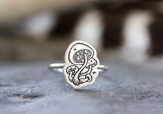 This listing is for one adorable and gorgeously detailed sterling silver magic mushroom ring. The mushroom focal piece is hand stamped onto 18 gauge sterling silver sheet and fired onto sturdy 14 gauge sterling silver wire. Wear this ring solo for simple elegance of wear it stacked with several hammered bands for an edgier, bohemian style! Perfect gift for any nature or woodland lover! It's such a magical ring! - Choose your ring size and stacking options at checkout! - Mushroom focal measures a Whimsical Adjustable Ring Jewelry, Whimsical Adjustable Jewelry Ring, Whimsical Adjustable Ring, Adjustable Whimsical Ring, Silver Whimsical Rings For Gifts, Whimsical Silver Rings For Gifts, Whimsical Silver Rings For Gift, Whimsical Adjustable Rings, Silver Whimsical Jewelry For Promise Ring