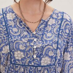 Embrace bohemian charm and effortless style with the Jasmine Blue Bohemian Tunic. Crafted from 100% viscose, this tunic offers both comfort and breathability, perfect for all-day wear. The vibrant blue pattern adds a lively touch to your look, making it a standout piece in your wardrobe. The 3/4 sleeves provide a relaxed yet polished look, while the inner lace detail on the placket adds a touch of femininity and elegance. Featuring a half placket adorned with shell buttons, this tunic exudes und Bohemian V-neck Rayon Peasant Top, Blue Bohemian Peasant Top In Relaxed Fit, Blue Bohemian Peasant Top With Relaxed Fit, Bohemian Rayon Blouse With Boho Print, Boho Bohemian-style Rayon Blouse, Blue Casual Tunic With Relaxed Fit, Blue Relaxed Fit V-neck Tunic, Blue Bohemian Printed Peasant Top, Blue Bohemian Relaxed Fit Tops