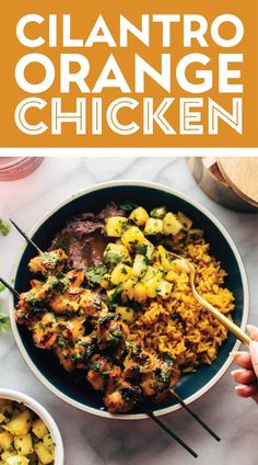 a bowl filled with chicken and rice next to chopsticks on top of a table