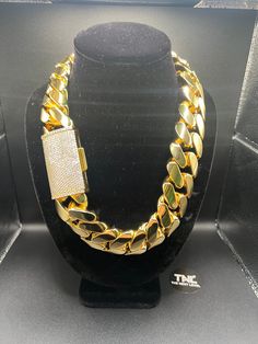 Want to be the center of attention? This one screams BALLER! A true statement piece that commands attention. Measuring a whopping 30mm in width and 1 KILO IN WEIGHT, this chain is one of the largest and most impressive pieces in our collection. Crafted from high-quality MIX OF stainless steel, PREMIUM BRASS, and plated in 7 layers of lustrous 14k gold, this chain is built to last and radiates a dazzling shine that is sure to turn heads. The classic Cuban link design adds a touch of sophisticatio Luxury Iced Out Link Jewelry, Luxury Gold Cuban Link Bracelet Iced Out, Luxury Modern Cuban Link Bracelet With Chunky Chain, Cheap Iced Out Gold Jewelry, Luxury Iced Out Cuban Link Necklace Gift, Luxury Cuban Link Necklaces For Men, Luxury Tarnish Resistant Cuban Link Necklace For Men, Luxury Tarnish-resistant Cuban Link Necklace For Men, Luxury Formal Cuban Link Necklace For Men