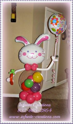 a balloon bunny is holding balloons in the shape of an egg and standing on its hind legs