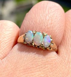 A glowing vintage natural trilogy opals set in solid 9karat yellow gold. The oval opals have flashes of purple,  yellow, red, green and blues depending on the light! Full English Birmingham hallmarks, this stunner is in superb vintage shape. US size 5, weighs 2.23 grams. Very comfortable and an absolute necessity in your ring collection! Thank you for looking! We do our best to list all item details and imperfections, however please keep in mind these are vintage, pre-loved items that may come n Victorian Opal Jewelry In Yellow Gold, Vintage Yellow Gold Opal Jewelry, Vintage Opal Jewelry In Yellow Gold, Victorian Yellow Gold Opal Jewelry, Victorian Opal Yellow Gold Jewelry, Vintage Opal Jewelry For Anniversary, Gold Opal Three-stone Oval Ring, Gold Oval Three-stone Opal Ring, Gold Oval Three Stone Opal Ring