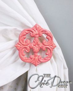 a pink brooch sitting on top of a white dress