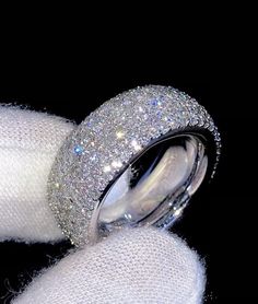 two wedding rings with diamonds on them sitting next to each other in white cloths