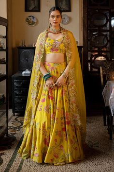 Lime yellow lehenga with multi colored floral print and hand embroidered highlights. Comes with matching silk based padded blouse and tissue based dupatta, heavily embellished with hand embroidery and detailing full of beads and sequins.
Components: 3
Pattern: Printed, Hand Embroidered
Type Of Work: Floral Patterns
Neckline: Plunged V-Neck
Sleeve Type: Sleeveless
Fabric: Lehenga and blouse : Chiniya silk, Dupatta : Tissue
Color: Yellow
Other Details: 
Lehenga:
Attached lining
Embroidered highlig Paulmi And Harsh, Lehenga And Blouse, Printed Lehenga, 1950’s Fashion, Floral Lehenga, Yellow Lehenga, Organza Lehenga, Embroidery Beads, Navy Blue Print