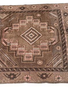 an old rug is shown on the floor with brown and pink colors, including diamonds