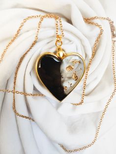 Explore the very essence of creativity with our heart-shaped necklace, passionately and artisanally crafted from UV resin. In this unique piece of jewelry, the refined marriage of gold, black and transparency comes to life, creating a piece that combines boldness and delicacy. UV resin, meticulously worked by your skillful hands, gives an artistic dimension to every detail. The golden heart, decorated with delicate leaves also shaped in resin, blends harmoniously into the transparent part, captu Resin Heart Necklace, Golden Heart, Heart Shaped Necklace, Gold Leaves, Gold Heart Necklace, Resin Pendant, Uv Resin, Gold Heart, Heart Of Gold