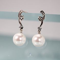 Enhance your style with these stunning sterling silver pearl dangle drop earrings! The elegant design features glistening cubic zirconia for a touch of sparkle. Perfect for any occasion, these earrings will elevate your look and make you feel confident and glamorous! Sold as a pairMaterials: 925 sterling silver, shell pearlsFinish: platinum plate, oxidationDimensions: 1.06 x 0.25 in Jewelry Care: See more information about how to care for your jewelry here. Shipping Policy: Orders will be shippe Elegant Bridal Earrings In Diamond White Cubic Zirconia, Elegant White Pearl Embellished Earrings, Elegant Pearl White Earrings With Pearl Drop, Elegant Pearl Dangle Earrings, Evening Pearl Drop Diamond Earrings, Elegant Pearl White Pearl Drop Earrings, Classic Sterling Silver Pearl Drop Earrings, Classic Sterling Silver Drop Pearl Earrings, Pearl Drop Cubic Zirconia Earrings For Party