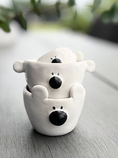 two ceramic cups with black and white bears in them