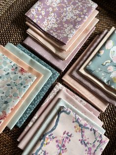 six different colored napkins sitting on top of a brown cloth covered table next to each other