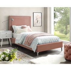 a bedroom with pink bedding and white rugs