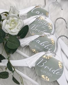 three bride hangers with white flowers and greenery