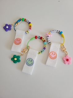 three bracelets with different designs on them sitting on top of a white table next to each other