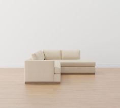 a white couch sitting on top of a hard wood floor next to a white wall