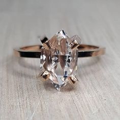 an oval cut diamond sits on top of a wooden table