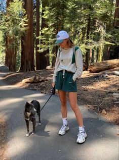 a woman is walking her dog in the woods