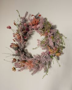 a wreath made out of dried flowers on a wall