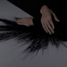 a person with their hand on top of some black and white hair that is spread across the floor