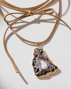 This necklace takes us back to where it all started but with a modern update. It features a sliced agate geode turned into a stunning pendant suspended from a generous length of faux (vegan) suede cord, allowing you to create your customized fit. Many believe that agate geodes possess metaphysical properties. They are thought to bring balance, stability, and protection to their surroundings. When cut open, the true beauty of the geode is revealed. The inner cavity is lined with agate bands and o Adjustable Agate Jewelry With Large Pendant, Adjustable Crystal Pendant Necklace For Parties, Adjustable Pendant Crystal Necklace For Party, Adjustable Agate Crystal Pendant Necklace, Agate Slice Jewelry, Geode Necklace, Front Back Earrings, Tie Wrap, Druzy Quartz