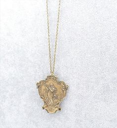 This stunning Art Nouveau style necklace featured a larger over sized stamped metal brass pendant depicting a romantic soft image of a Maiden Goddess playing a Musical harp. The pendant also features many flowers and a dragonfly on the bottom. The pendant is hollow on the back so it is very light weight - please view all pictures to see the back. The pendant is large and measures 2 1/2 inches long by 2 inches wide. I have suspended this pendant from a brass cable chain complete with a lobster cl Maiden Goddess, Filigree Pendant Necklace, Art Nouveau Flowers, Romantic Jewelry, Dragonfly Jewelry, Goddess Necklace, Stamped Metal, Romantic Jewellery, Floral Pendant