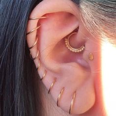 a woman with long black hair wearing gold ear piercings