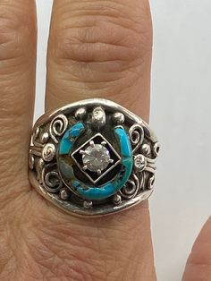 For your consideration I have a beautiful handmade Sterling Silver Turquoise and cubic zirconia Native American ring that has a marking of CW. This ring is used. Please note that the one part of the horseshoe that holds the turquoise it is damaged. Still with that this ring is beautiful. This ring is a size 12 3/4 and weighs 11.4 grams. The horseshoe measures 14mm wide and 14mm tall. Turquoise Sterling Silver Jewelry With Center Stone, Southwestern Inlay Jewelry For Anniversary, Southwestern Style Inlay Jewelry For Anniversary, Bohemian Inlay Jewelry For Anniversary, Southwestern 925 Stamped Jewelry For Anniversary, Western Sterling Silver Gemstone Ring, Western Style Sterling Silver Gemstone Ring, Western Style Turquoise Sterling Silver Ring, Southwestern Multi-stone Jewelry For Anniversary