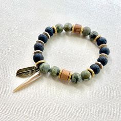 The green beaded bracelet is an authentic piece of Native American jewelry, inspired by nature and crafted in a bohemian style. This spiritual protection bracelet is perfect for men seeking a meaningful and culturally significant accessory. 🪶 𝗠𝗔𝗧𝗘𝗥𝗜𝗔𝗟𝗦 + 𝗗𝗜𝗠𝗘𝗡𝗦𝗜𝗢𝗡𝗦 ❯  10mm Rhyolite, Jasper, Wood, Abalone Shell, Brass ❯  Heavy Duty Elastic Cording 🪶 𝗦𝗧𝗢𝗡𝗘 + 𝗘𝗟𝗘𝗠𝗘𝗡𝗧 𝗘𝗡𝗘𝗥𝗚𝗬 ❯  NUMEROLOGY POWER OF 1 signifying courage, focus, will, and enlightenment ❯  RHYOLITE offers the energy of self-esteem ❯  JASPER clears electromagnetic and environmental pollution ❯  WOOD symbolizes life, growth and strength 🪶 𝗣𝗘𝗥𝗦𝗢𝗡𝗔𝗟𝗜𝗭𝗔𝗧𝗜𝗢𝗡 + 𝗚𝗜𝗙𝗧 𝗦𝗘𝗧 𝗦𝗨𝗚𝗚𝗘𝗦𝗧𝗜𝗢𝗡𝗦 ❯  Wood Bracelet Tray, with or without a monogram + cotton travel bag (photo 7) ❯  Ar Handmade Earthy Beaded Bracelets For Healing, Bohemian Gemstone Beads Friendship Bracelets, Artisan Green Beaded Bracelets For Beach, Earthy Beaded Bracelets With Natural Stones For Meditation, Adjustable Beaded Nature-inspired Bracelet, Rustic Beaded Bracelets With Natural Stones, Nature-inspired Adjustable Beaded Bracelet With Round Beads, Earthy Gemstone Beads Bracelets For Meditation, Artisan Green Handmade Bracelets