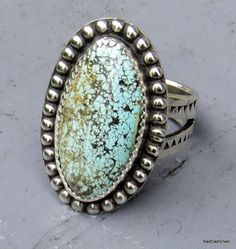 "Lets just say that the speckled Royston Turquoise stone that I cut and shaped and polished from the rough, looks like those found in the gizzard of a dinosaur. Don't let that put you off, just the opposite, it is beautiful, totally one of a kind and very rare.  I painstakingly set it in a serrated and beaded sterling silver bezel. I custom stamped the split shaft ring shank.  The silver beading is a royal pain which is why you don't see much, but the stone was worth the trouble.   The all natur Southwestern Sterling Silver Turquoise Ring With Natural Stones, Southwestern Silver Turquoise Ring With Natural Stones, Untreated Sterling Silver Rings With Rustic Style, Rustic Sterling Silver Turquoise Ring Gift, Rustic Silver Turquoise Ring Gift, Rustic Silver Turquoise Ring For Gift, Rustic Silver Oval Jewelry, Handmade Rustic Silver Turquoise Ring, Southwestern Oval Turquoise Ring With Natural Stones