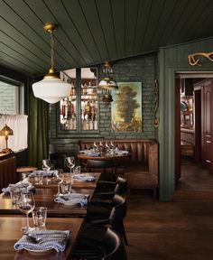 a dining room with wooden tables and black chairs, green walls and wood flooring