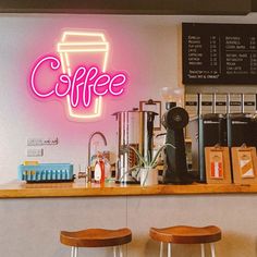 a coffee shop with neon sign above the counter