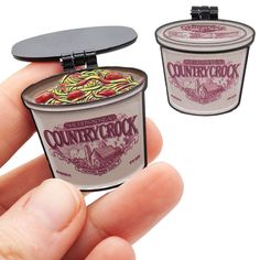 a hand holding an ice cream container shaped like a pint sized cup with the word country crook printed on it