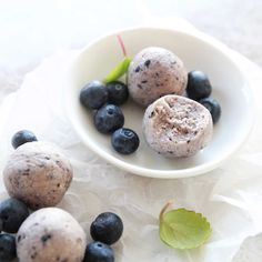 some blueberries are in a white bowl