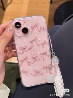 someone is holding their phone case with pink bows on it