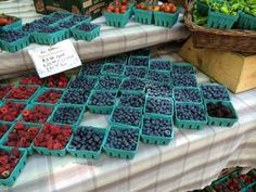 several trays of berries are on display at a farmers market