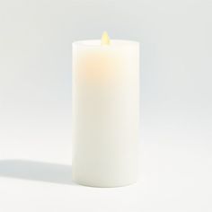 a white pillar candle with a yellow wax in the middle on a white background,