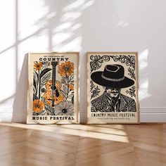 two posters are on the floor in front of a white wall, one is wearing a hat and the other has an orange flower