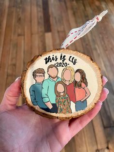 a hand holding a wood slice with an image of two people on it that says, this is co