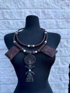 Expertly crafted in Mali, the Barimah Oversized Unisex Tuareg Necklace exudes the charm and elegance of traditional Tuareg culture. Handmade with genuine leather, this stunning necklace brings a touch of the desert to any outfit. Brown Medallion Amulet Necklace, Bohemian Brown Ceremonial Jewelry, Brown Leather Pendant Necklace, Unique Brown Jewelry For Ceremonial Occasions, Traditional Adjustable Leather Jewelry, Traditional Medallion Necklace With Detachable Pendant, Brown Fair Trade Necklace For Festival, Traditional Leather Jewelry For Festival, Artisan Adjustable Ceremonial Necklace