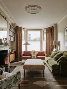 a living room filled with furniture and a fire place in front of a large window