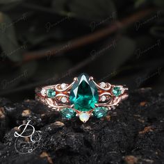 a ring with an emerald and white topazte surrounded by diamonds on a rock