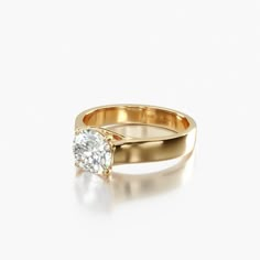 a yellow gold ring with a single diamond in the center, on a white background