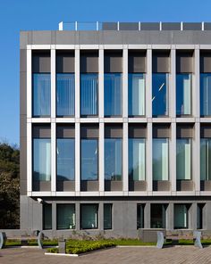 the building has many windows and benches in front of it