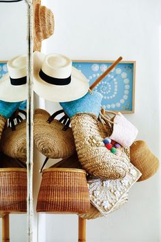 two hats are sitting on top of each other in front of a wall with pictures