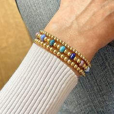 14K gold-filled or sterling silver 2mm, 3mm, & 4mm beads; colorful glass seed beads; 6mm glass bubble beads; stretch style. Water safe, tarnish-resistant. Great solo or stacked. Bracelet Size Guide Blue Crystal Bracelet With Stackable Round Beads, Blue Stackable Jewelry With Round Beads, Blue Stackable Stretch Bracelet, Stackable Blue Stretch Bracelet, Blue Stackable Stretch Bracelet For Everyday, Everyday Stackable Blue Bracelets, Blue Stackable Beaded Bracelets As Gift, Blue Spiritual Stackable Beaded Bracelets, Blue Stretch Bracelet With Tiny Beads