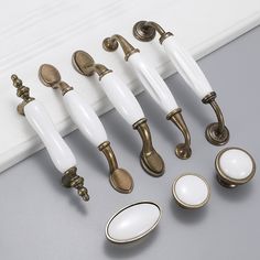 an assortment of door handles and knobs on a gray surface with white trimming