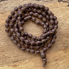 "📿Tulsi Mala handcrafted with Brown Tulsi beads. Suspended in the center is the engraved \"Krishna & Radha\" Guru Bead. When someone wears the tulsi mala, around your neck or around your wrist, you feel protected and focussed. It actually goes a long way in helping you deal with the stress of modern life.📿 🚪 Dimensions ( Approximately ) 🚪 📏Bead size: 11 MM - 12 MM 📏No. of beads: 108 Mala Bead + 1 Guru Bead 📏Mala Necklace Length: 50.0 - 51.0 inches 🚪 Pure Tulsi Beads Sourced from Vrindava Natural Wooden Beads Spiritual Bracelet, Traditional Natural Necklace For Meditation, Meditation Jewelry With Wooden Round Beads, Meditation Jewelry With Round Wooden Beads, Wooden Beads Jewelry For Meditation, Artisan Wooden Beads Bracelet For Meditation, Traditional Natural Beads As A Gift, Traditional Natural Beads For Gifts, Traditional Natural Beaded Necklaces As Gift