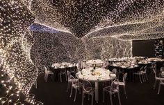 a room filled with tables and chairs covered in lights